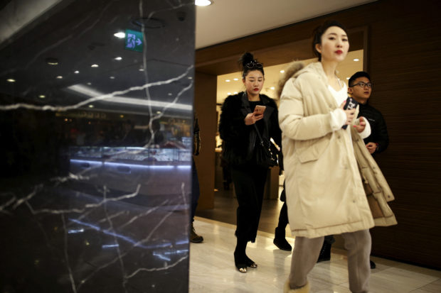 Chinese tourists hop at a Lotte duty free shop in Seoul