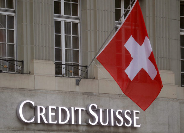 Switzerland flag flies above the logo of Credit Suisse