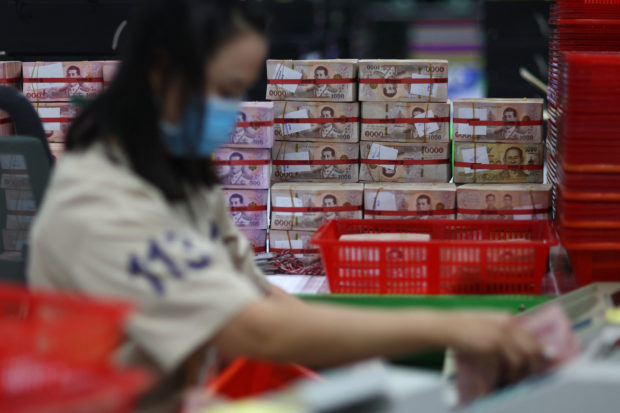 Baml employee gatjers Thai baht banknotes