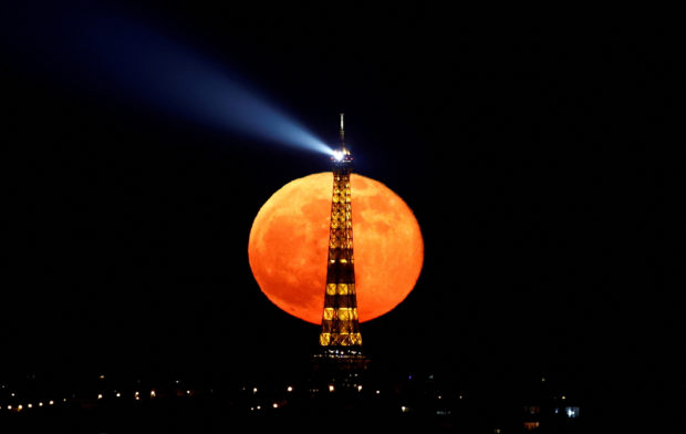 "Super Pink Moon" rises behind the Eiffel Tower in Paris