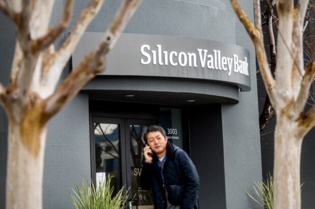 A pedestrian speaks on a mobile telephone as he walks past Silicon Valley Banks headquarters in Santa Clara, California on March 10, 2023. - US authorities swooped in and seized the assets of SVB, a key lender to US startups since the 1980s, after a run on deposits made it no longer tenable for the medium-sized bank to stay afloat on its own. (Photo by NOAH BERGER / AFP)