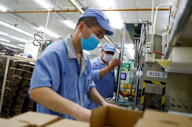 Men work in a factory in Beijing