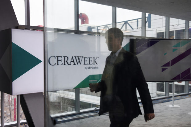 An attendee walks as CERAWeek 2023 opens