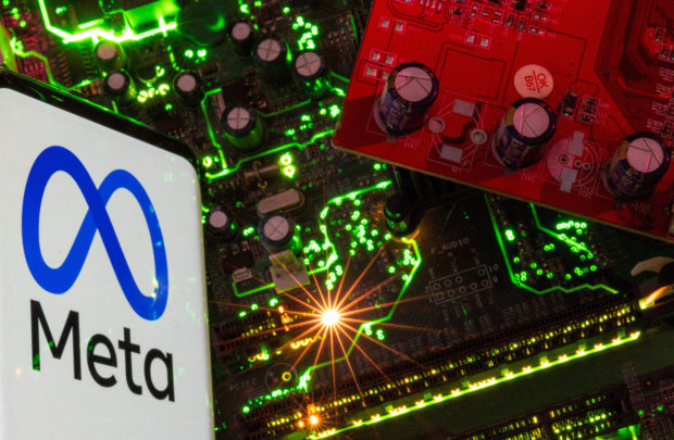 Smartphone displaying Meta logo on a computer motherboard