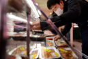 An employee works at a meat corner of a store in Tokyo