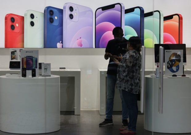 A salesperson speaks to a customer at an Apple store in Mumbai