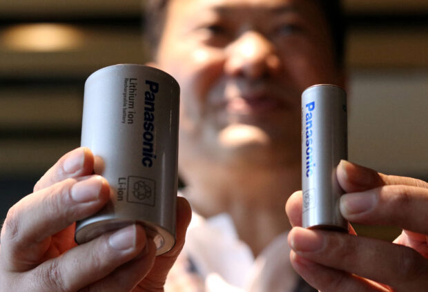Kazuo Tadanobu holds prototype of 4680 format battery cell