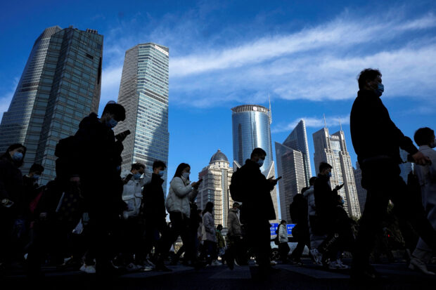 People walk on a street in the financial district of Shanghai