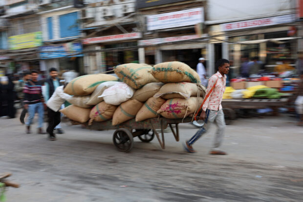 Workers transport sacks at a wholesale market in 