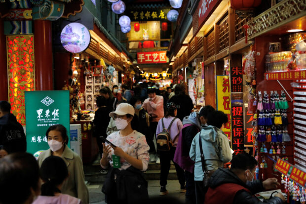 People in a market at the tourism site of Qianmen St. in Beijing