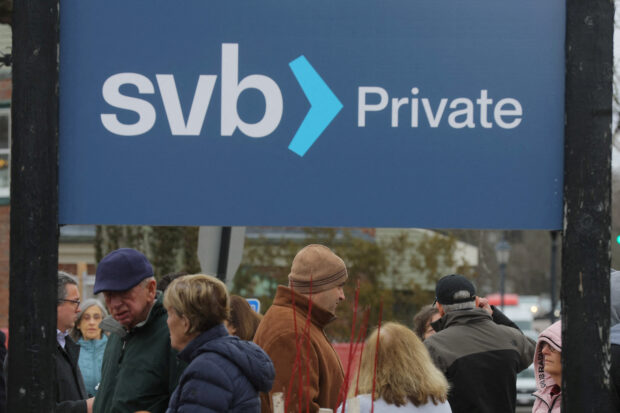 Customers wait in line outside a branch of Silicon Valley Bank
