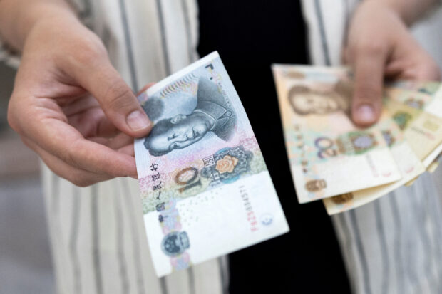 A person holding Chinese yuan banknotes