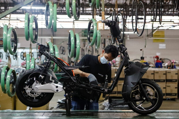 Employees work at the assembly line of e-motorcycle  plant in Bogor