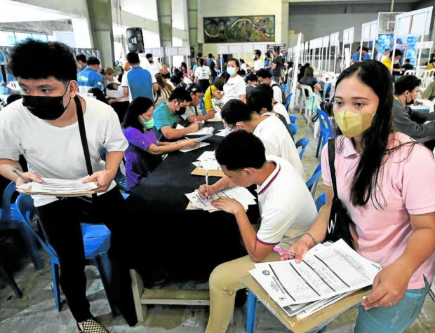 Applicants fill up forms at the Public Employment Service Office in Manila on Feb. 24, 2023.