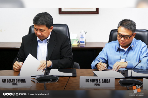 MIAA chief Cesar Chiong and IPOPHL director general Rowel Barba signing agreement on fight vs counterfeits