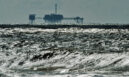 An oil and gas drilling platform stands offshore near Dauphin Island in Alabama