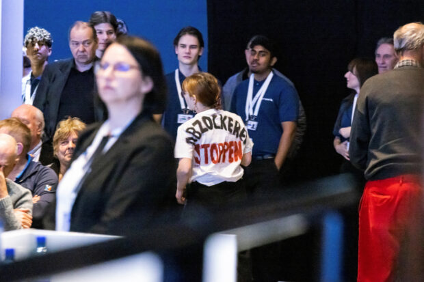 A shareholder wears a t-shirt with "stop rip off" written on its back 