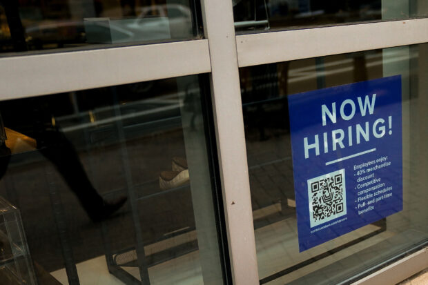 An employee hiring sign in a window of an establishment in Arlington, Virginia