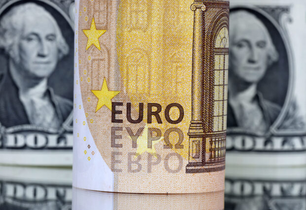 A euro bank note in front of dollar bills