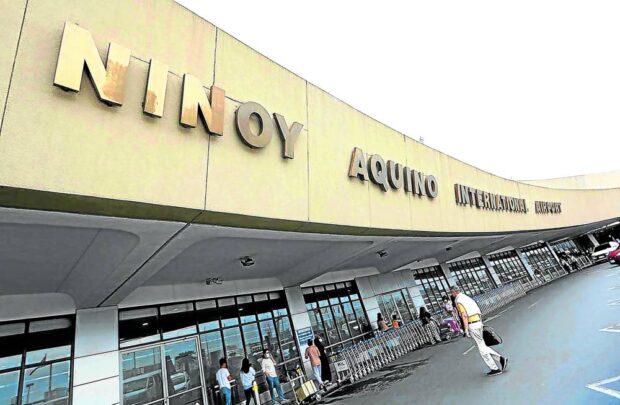 TO REDUCE STRESS Passengers line up at the entrance of the departure area of Ninoy Aquino International Airport Terminal 1. The Department of Transportation took a step closer to rehabilitating the “stressful” airport. —FILE PHOTO