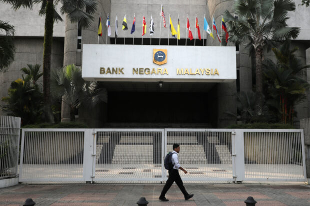 A man walking past the entrance of Central Bank of Malaysia