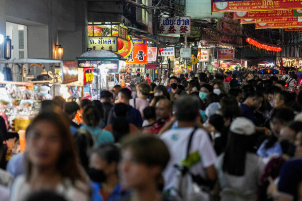 Tourists shop for street foods in Bangkok's Chinatown