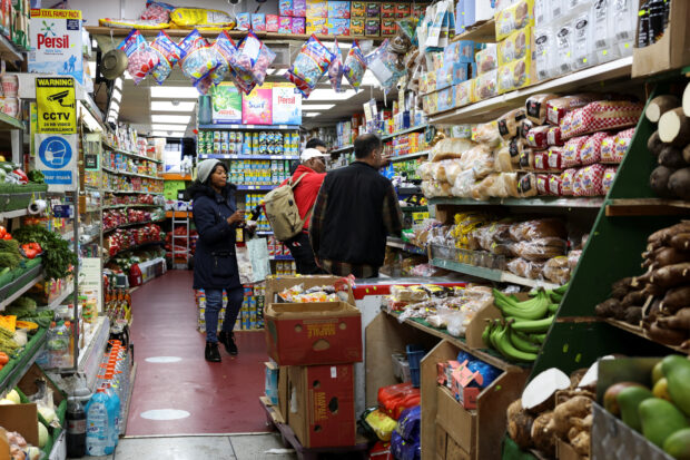 People shop at a grocery market in London