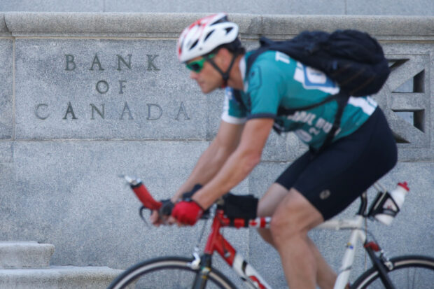 A cyclist rides past the Bank of Canada building in Ontario
