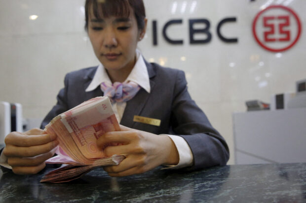 ICBC bank teller counts yuan banknotes