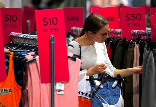 Shopper checking out items on sale at a clothing store in Sydney