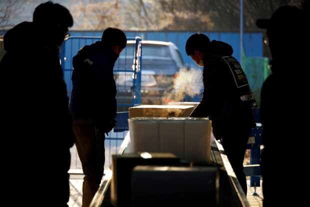 Delivery workers sort parcels at a Hanjin distribution center in Gwangju