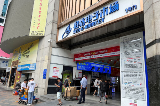 People stand outside the SEG e-Market at Huaqiangbei electronics market in Guangdong 