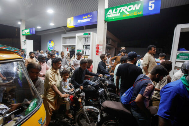 People wait their tur to get fuel at a petrol station