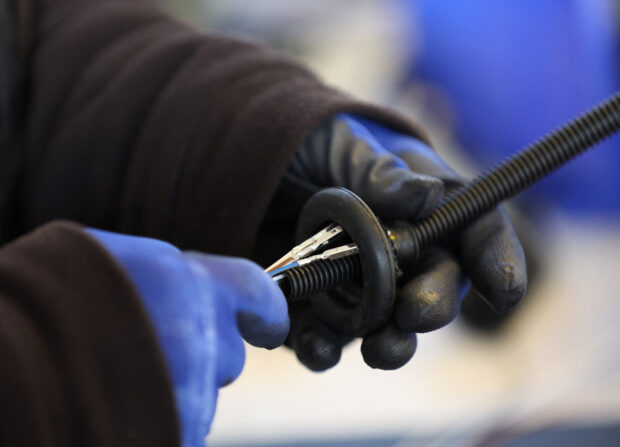 A worker assembles an electrical component at the Aurrigo factory in Britain