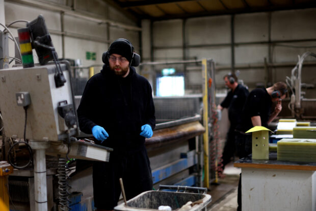 Men working at factor in Altrincham, Britain