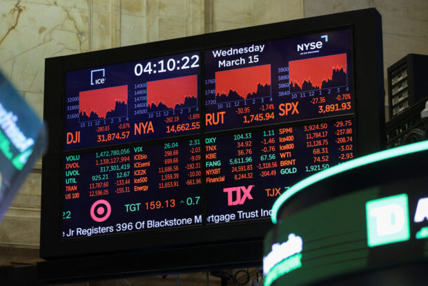 A screen displays the Dow Jones Industrial Average at NYSE