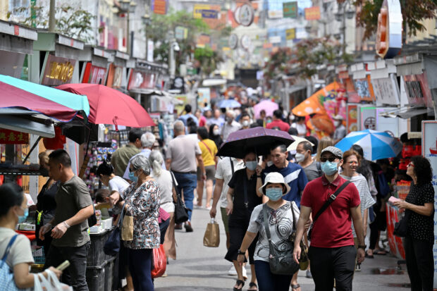 Visitors walk along rows of shops in Chinatown in Singapore