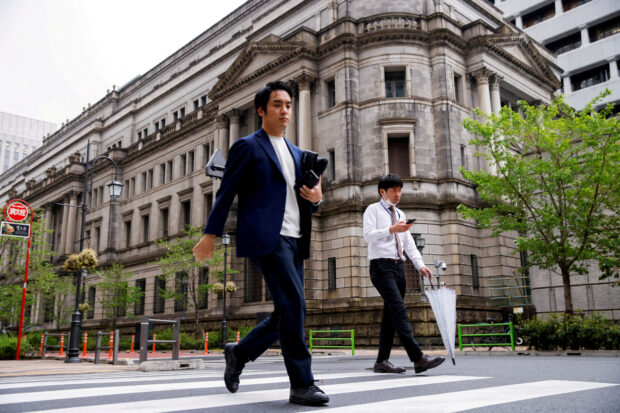 People walk in front of the Bank of Japan building