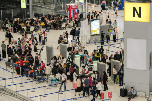Tourists wait to check in for flights in Bangkok's Suvarnabhumi airport in Thailand