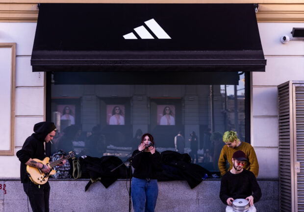 Musicians play in front a closed Adidas store in Central Moscow