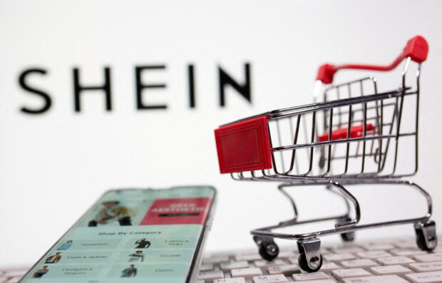 A keyboard and a shopping cart are seen in front of a Shein logo