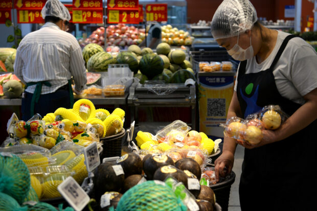 Staff sort fruits at a Walmart in Beijing