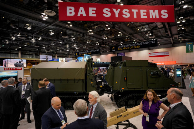 People gather at the BAE Systems' booth 