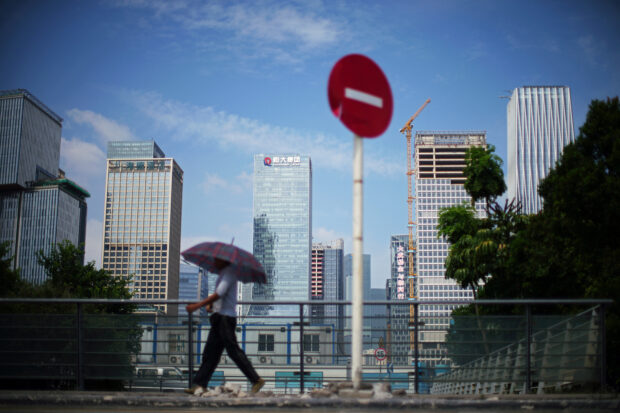 Man walks past a No entry sign near the headquarters of China Evergrande Group