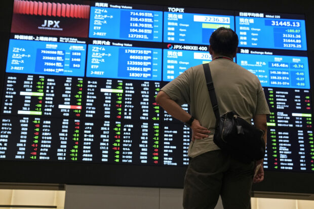 A man looks at an electronic stock board at the Tokyo Stock Exchange