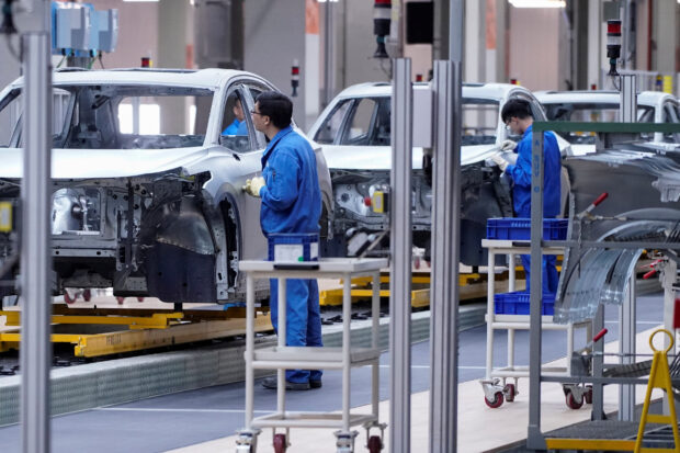 Employees work on an assembly line of SAIC Volkswagen electric vehicle plant