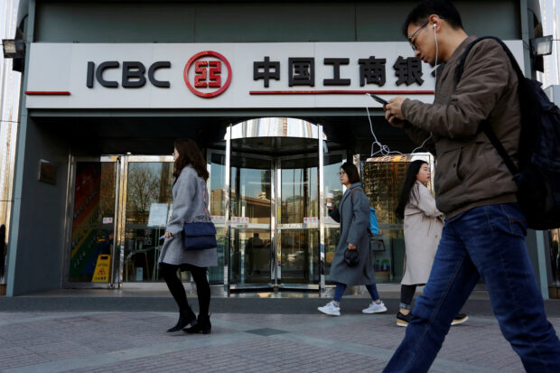 People walk past a branch of Industrial and Commercial Bank  of China 