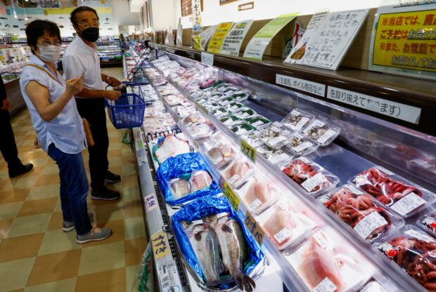 Customers check on locally caught seafood at Hamanoeki Fish Market in Fukushima