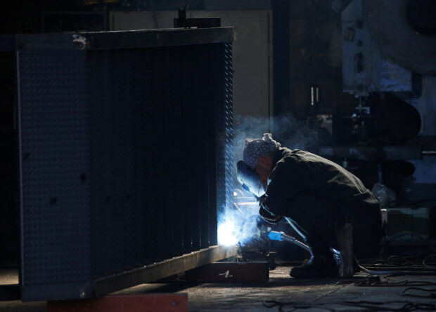 A man works at a factory at Keihin industrial zone in Kawasaki