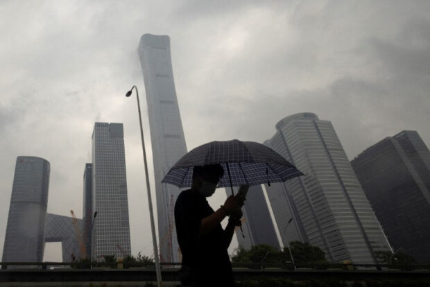 A man walks in the central business district in Beijing on a rainy day